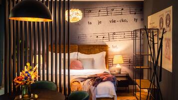 Un dormitorio moderno con cama, mesita de noche, lámpara y una pared decorada con notas musicales.