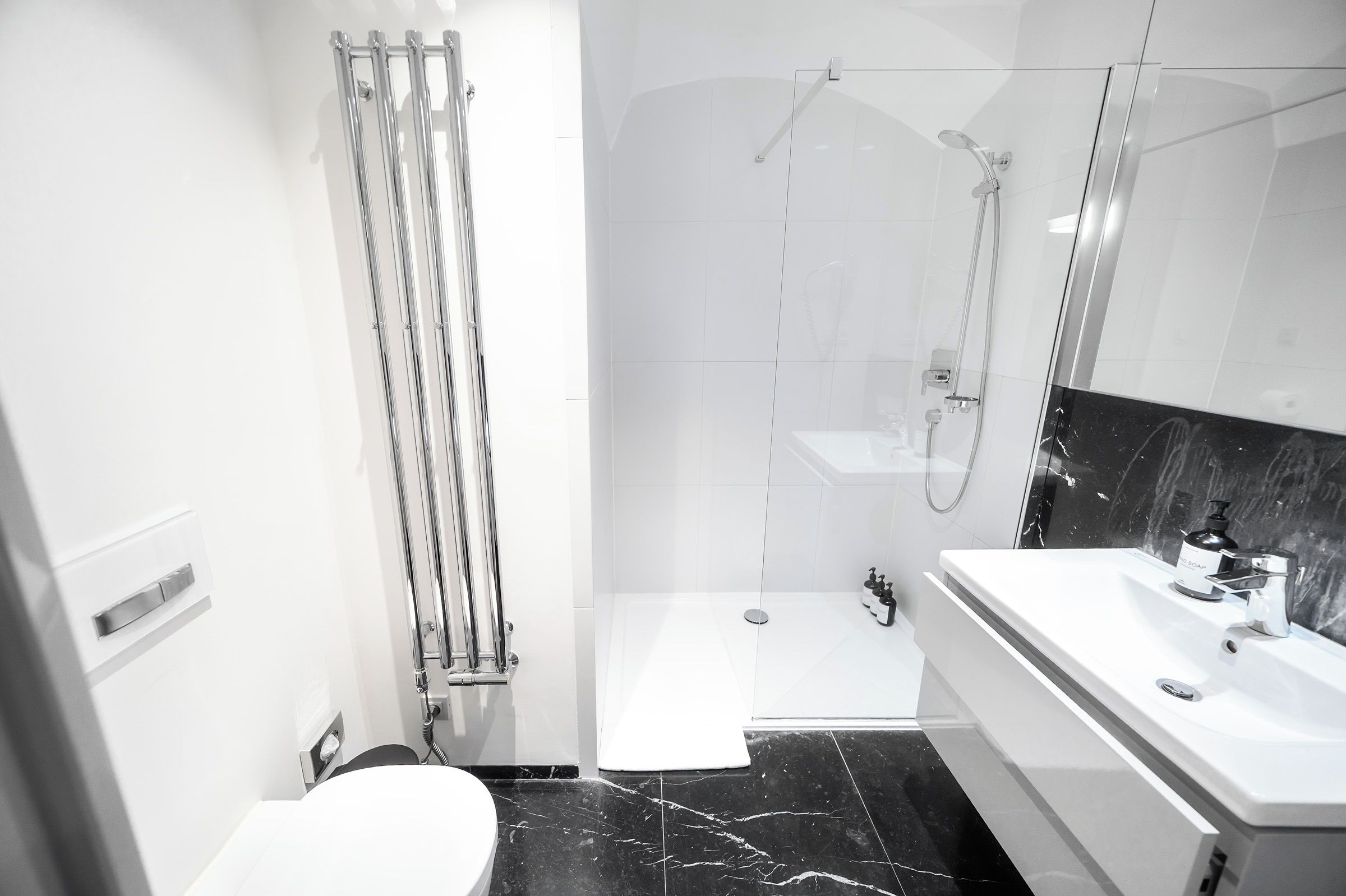 A modern bathroom with a shower, toilet, and sink.