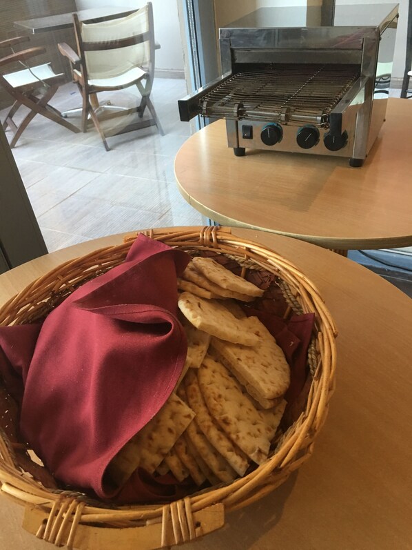 Un panier en osier rempli de galettes et un tissu rouge sur une table.