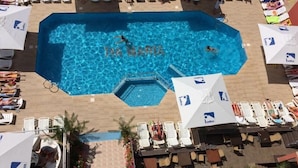A swimming pool with a hexagonal shape, surrounded by lounge chairs and umbrellas. - TM Deluxe Hotel (Sunny Beach)