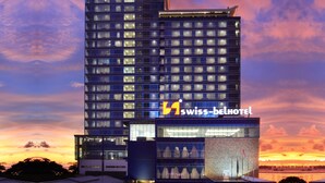 Un hôtel moderne, reconnaissable à son enseigne bien visible où l’on peut lire « Swiss-Belhotel ».