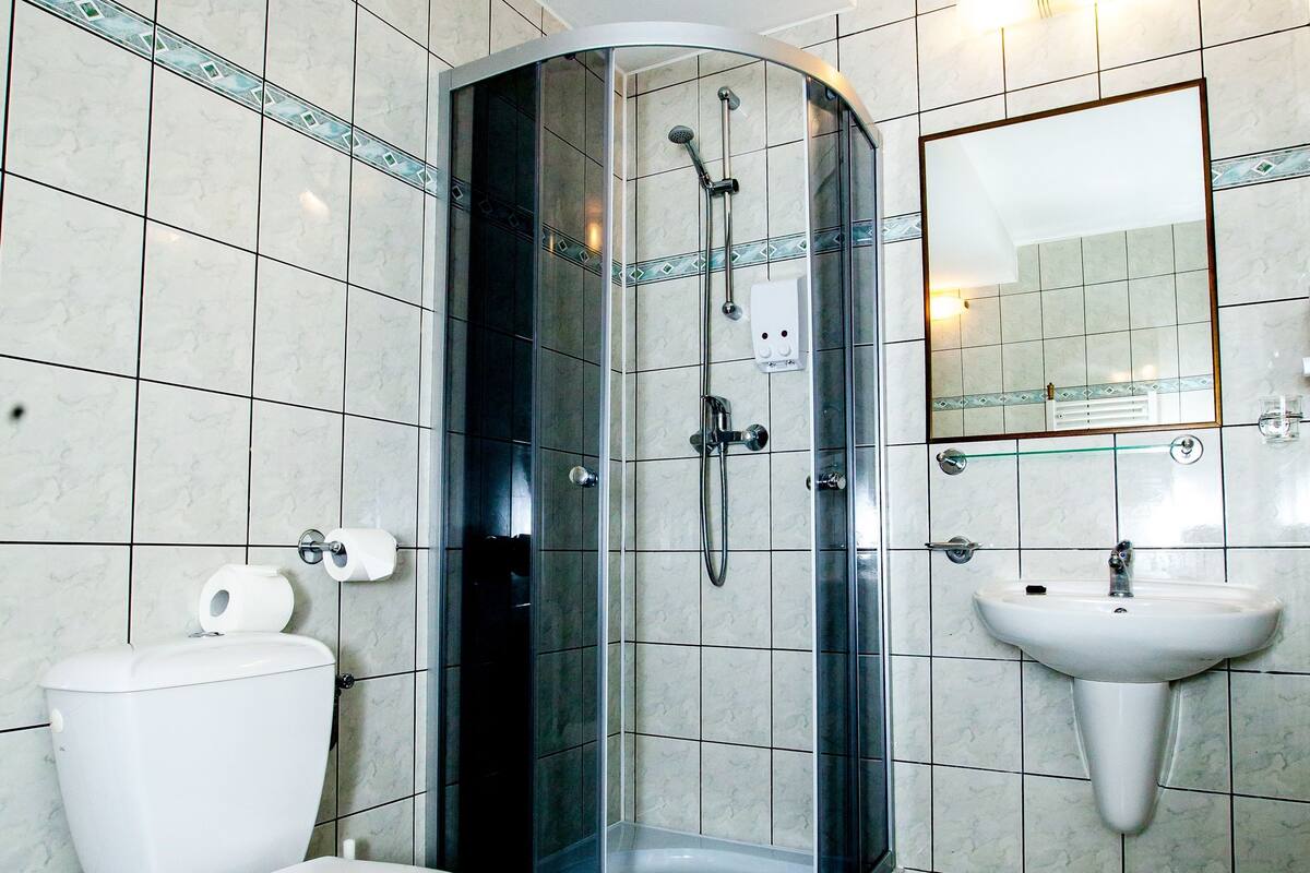 A bathroom with a toilet, a sink, and a glass-enclosed shower.