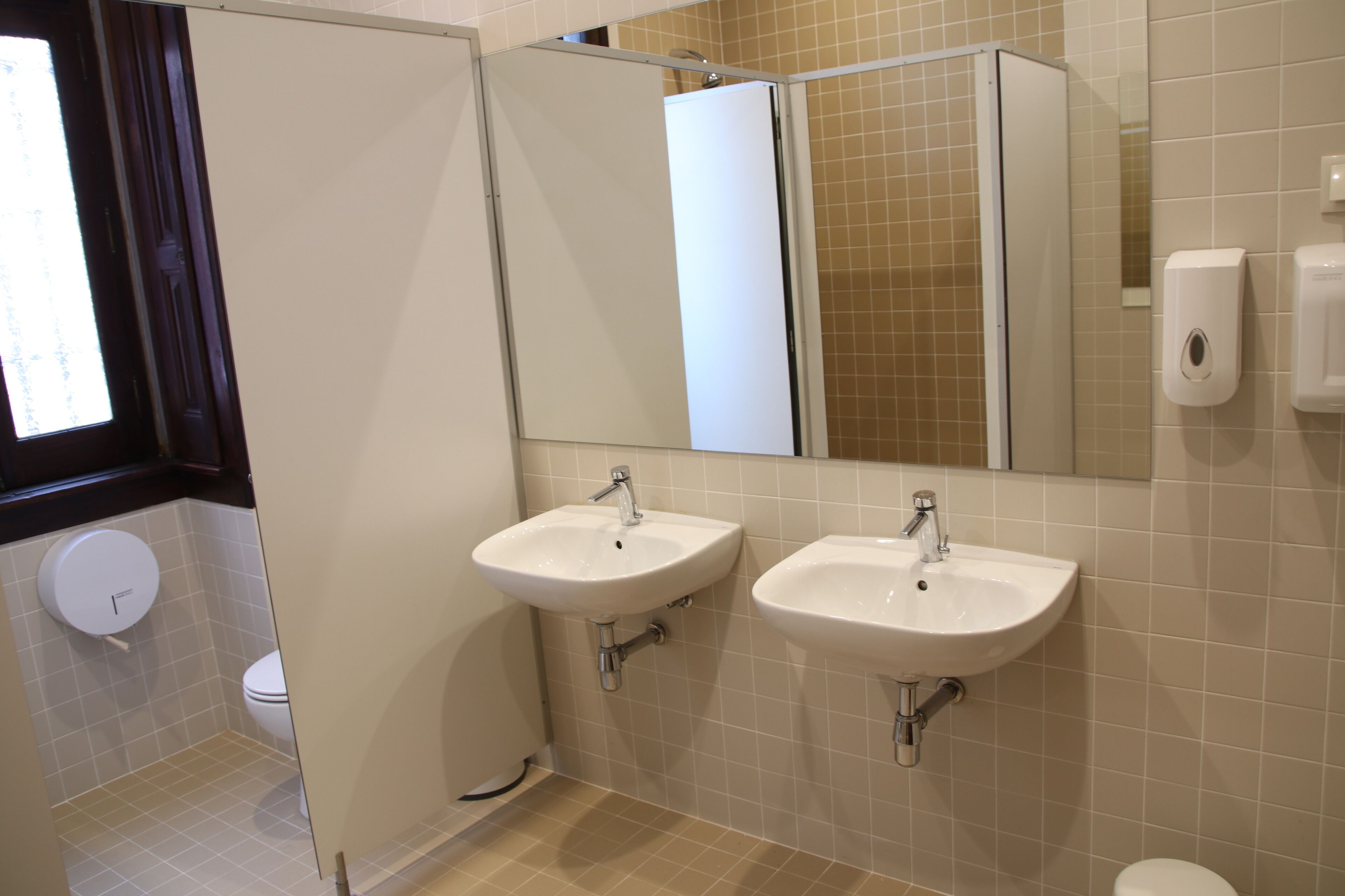 Ein Badezimmer mit zwei Waschbecken, einer Toilette und einer Dusche.