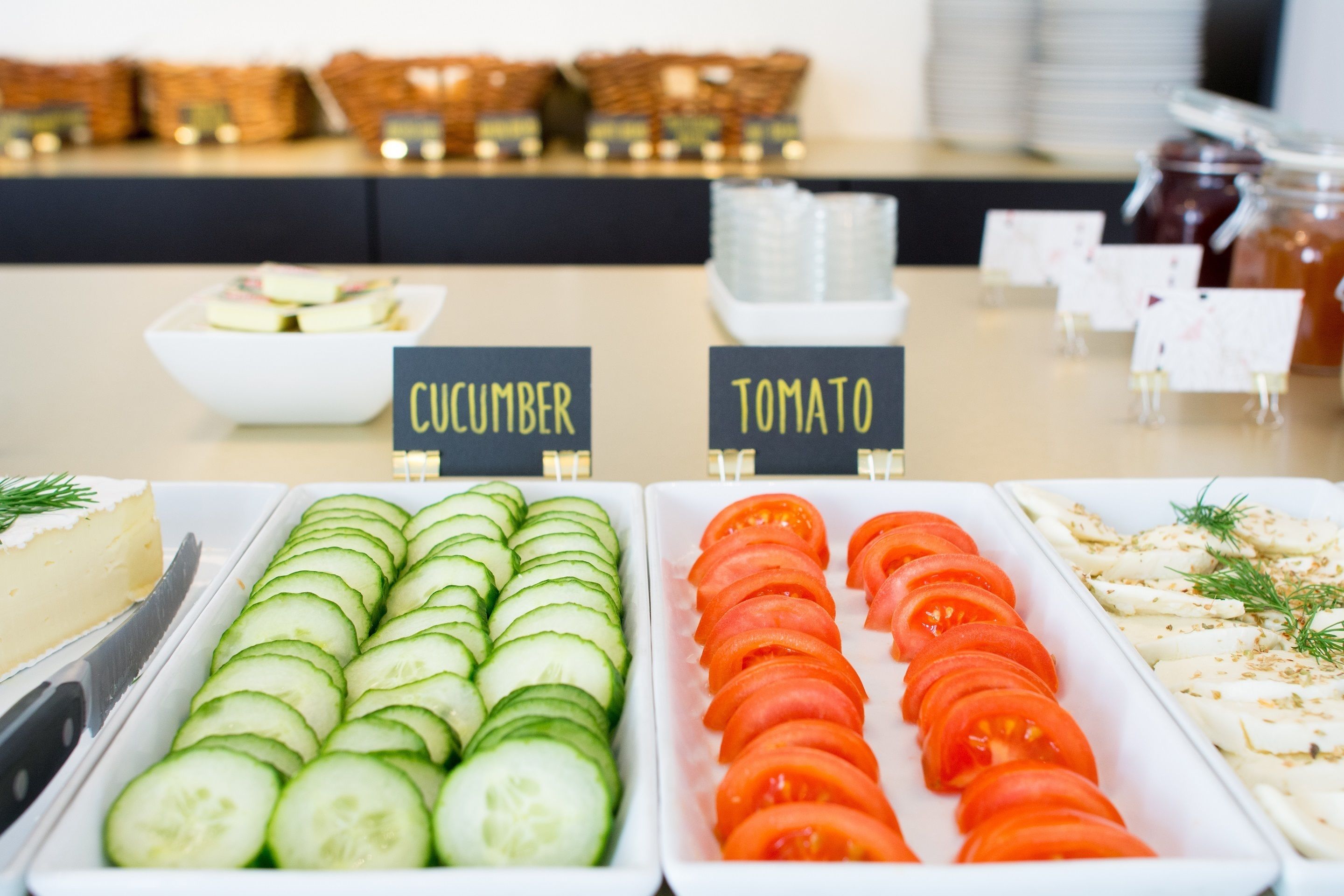 Un buffet con sezioni distinte per fette di cetriolo e pomodoro.