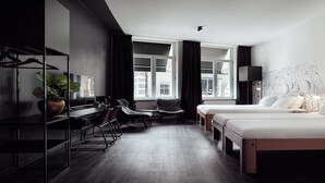 A modern hotel room with two beds, a desk, and a chair. - MABI City Centre (Maastricht)