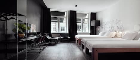 Habitación de hotel moderna con dos camas, un escritorio y una silla.