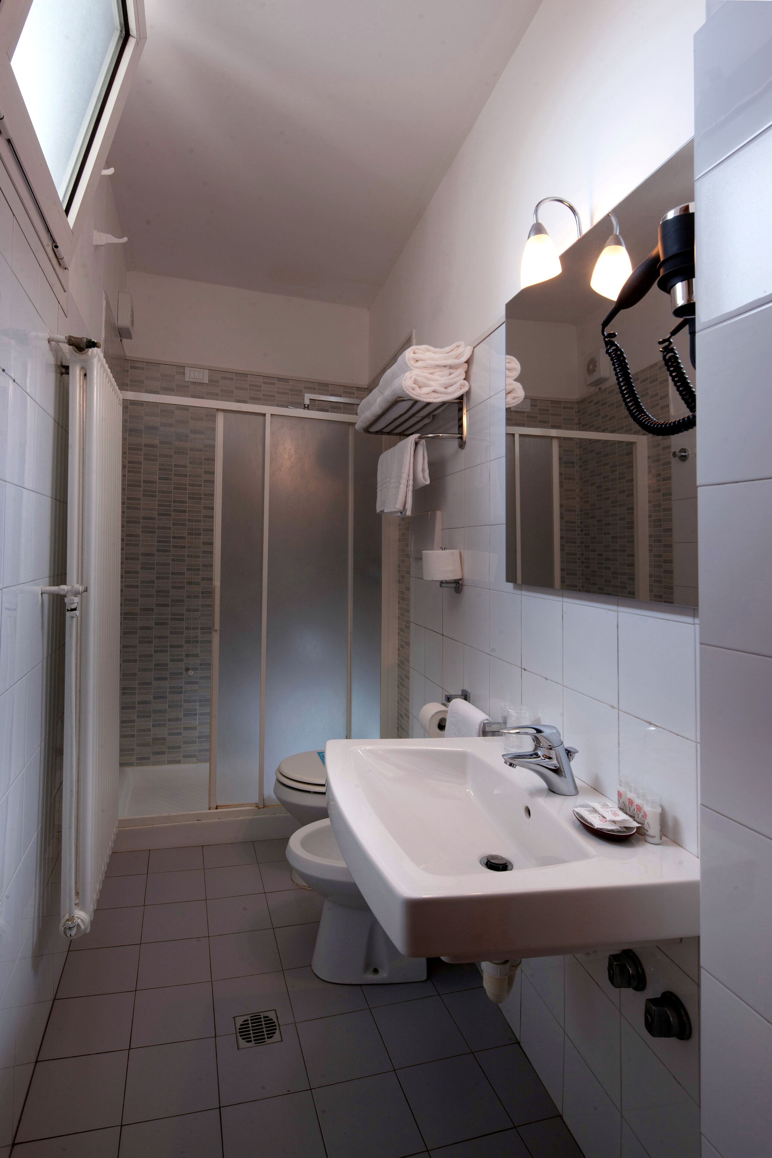 Ein Badezimmer mit Dusche, Toilette, Waschbecken und Spiegel.