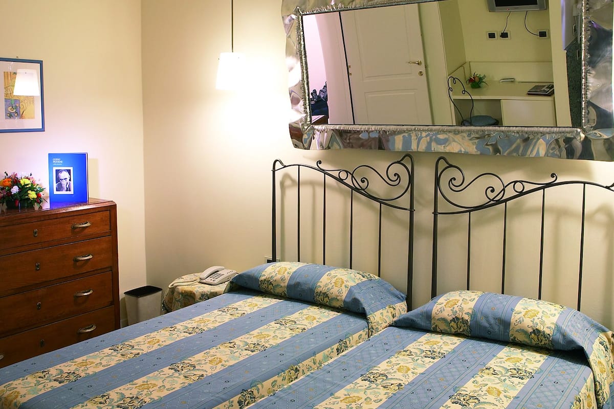 Un dormitorio con cama, cómoda y espejo.