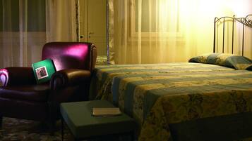 Una camera d'albergo con un letto, una sedia, un tavolino e una porta.