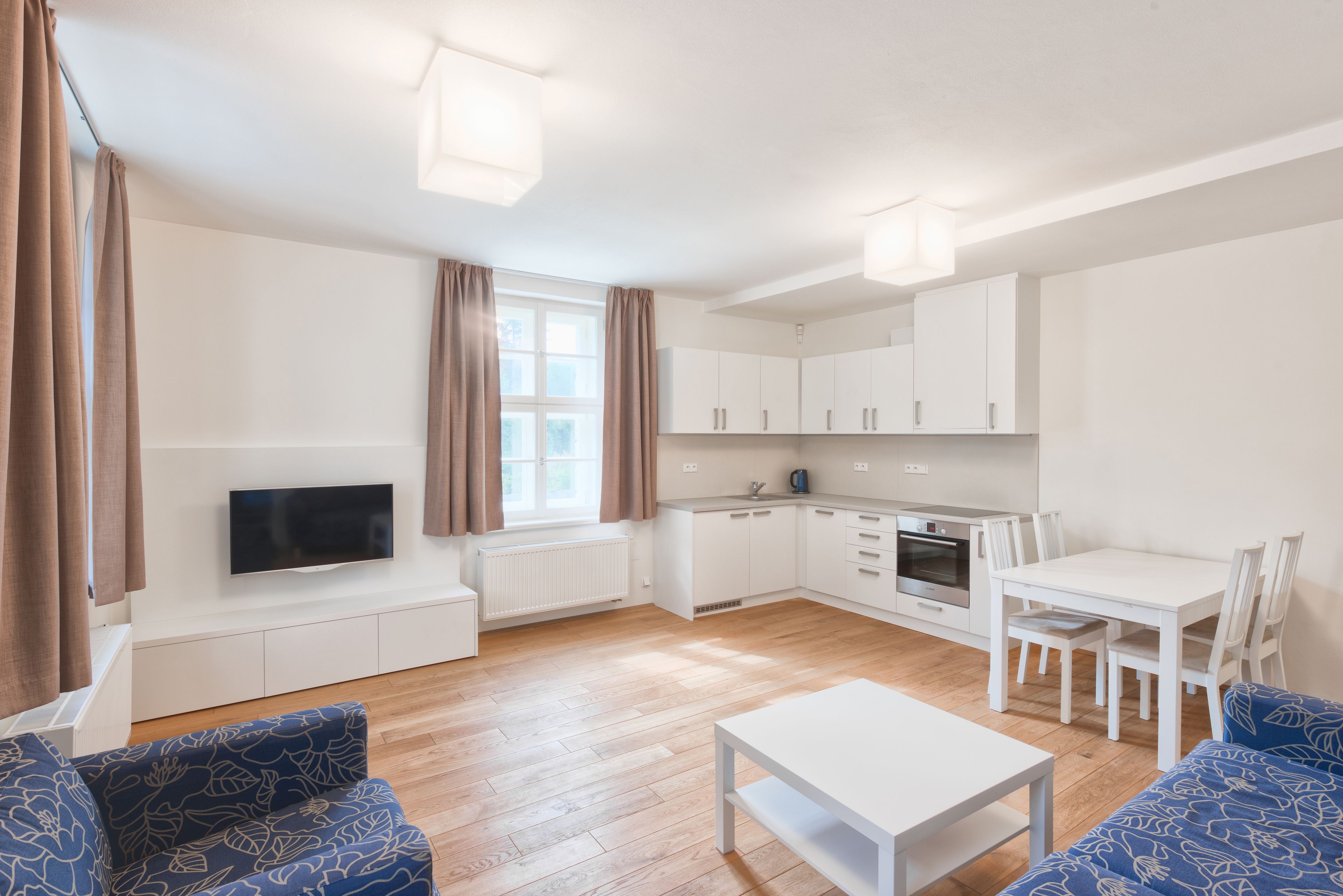 Een modern appartement met een woonkamer, eethoek en keuken.