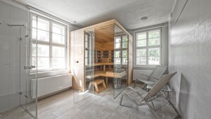 A modern room with a glass partition, a wooden reading nook, and a seating area. - Theresian Apartment (Ostruzna)
