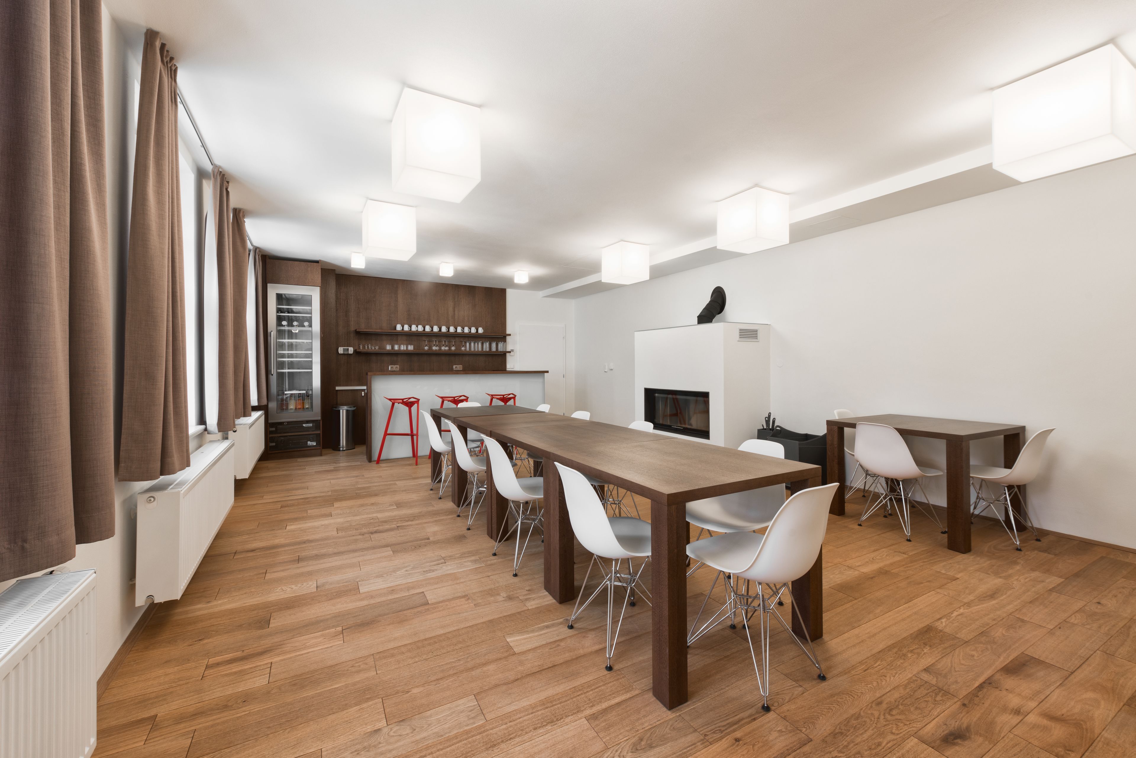 Een moderne keuken met houten kastjes, een witte koelkast en een zwart aanrecht.