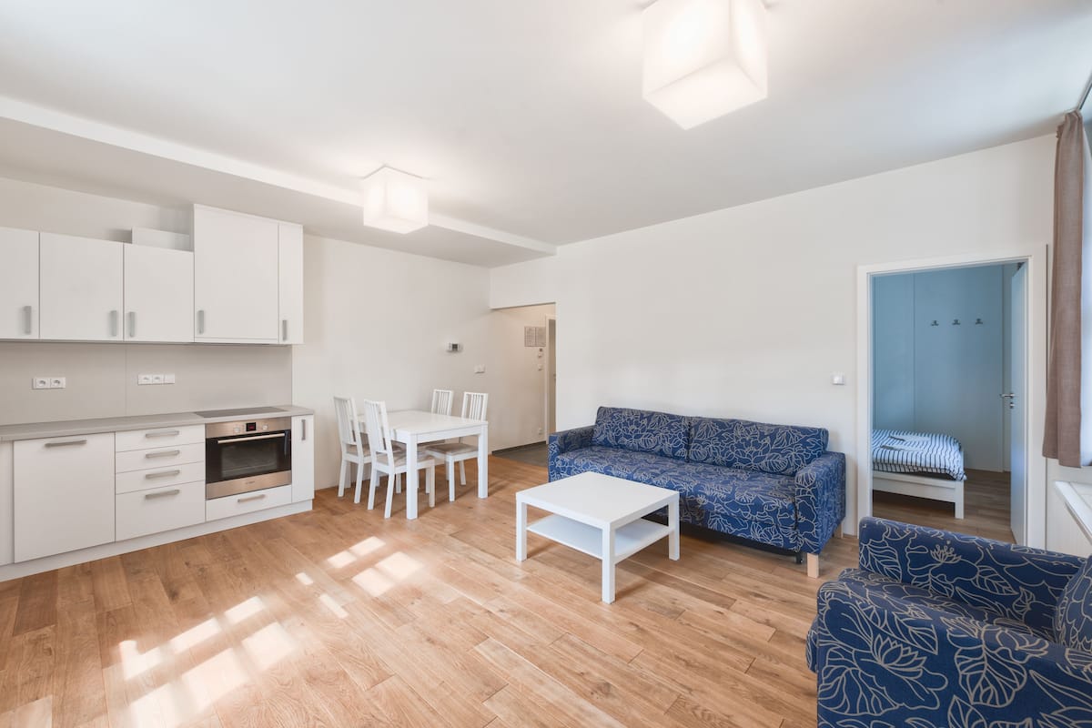 Un salon moderne comprenant un canapé, une table basse et un coin repas avec des chaises et une table.