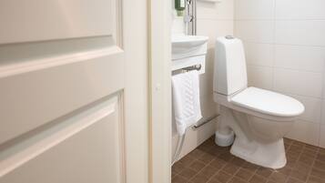 Une salle de bain équipée de toilettes, d’un lavabo et d’une douche.
