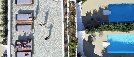 Een buitenzwembad, parasols voor strand/zwembad