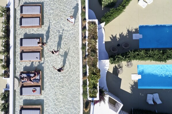 Una piscina al aire libre, sombrillas, tumbonas