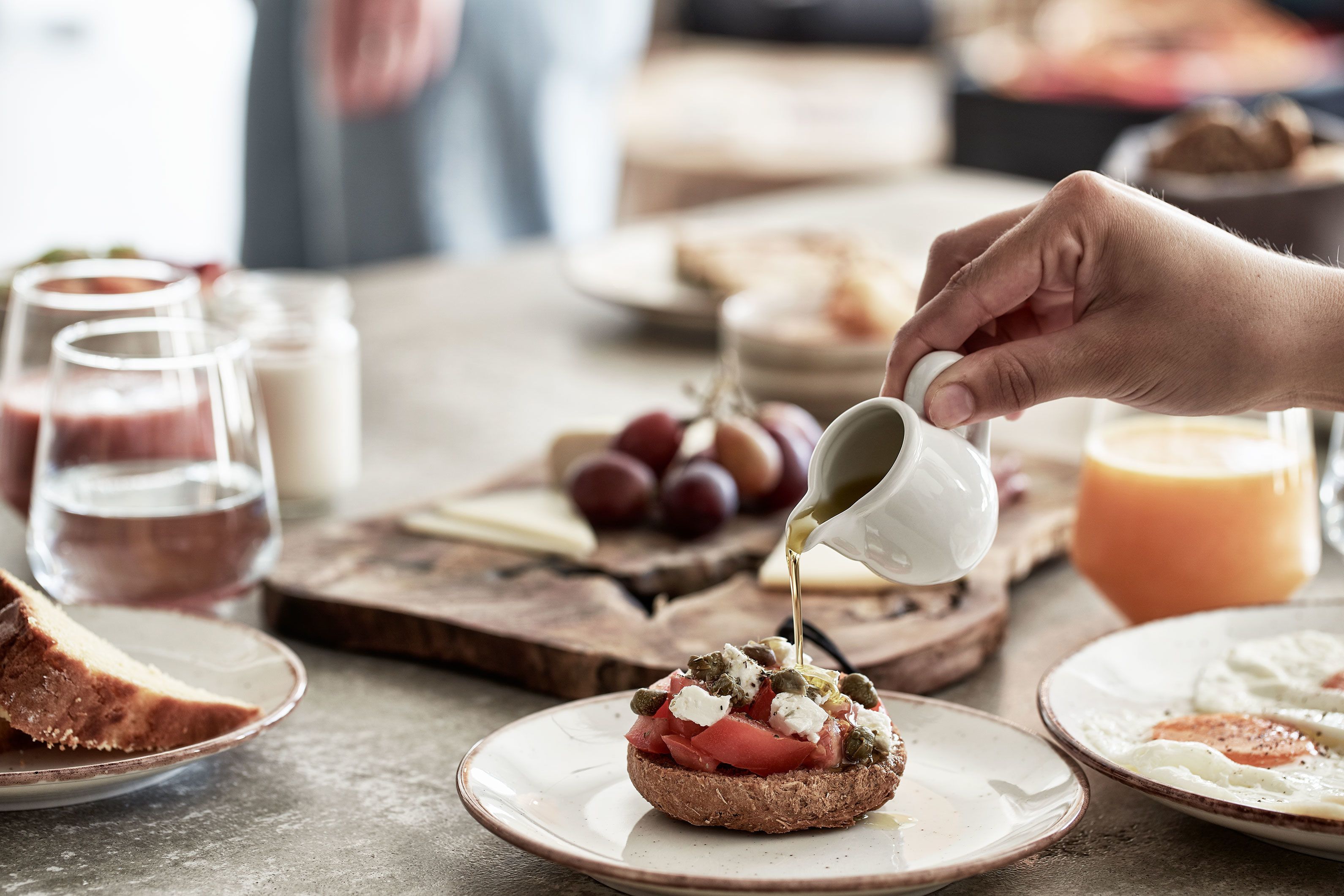 Iemand giet een vloeistof over eten op een bord.