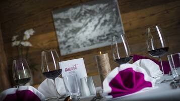 Una mesa servida con copas de vino, una vela y una tarjeta de menú en un hotel.