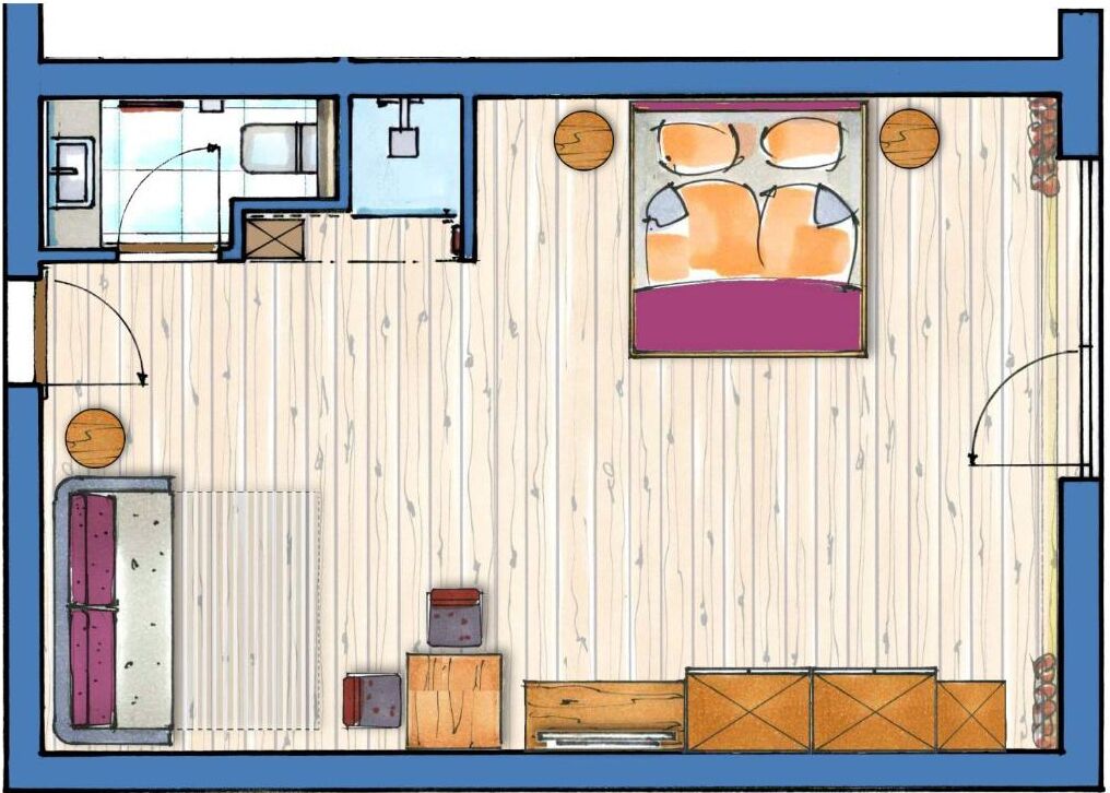 A bedroom with a bed, bedside tables, a wardrobe, and a small seating area.