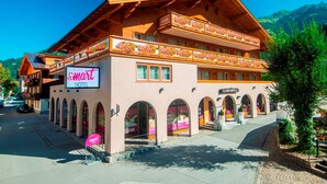 A hotel with a sign reading "Smarat Hotel," featuring a wooden facade, multiple balconies with flower boxes, and a view of the surrounding area. - smartHOTEL (Dorfgastein)