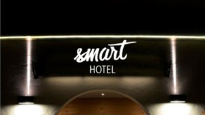 A hotel entrance with a modern design, featuring a glass door and a staircase leading up. - smartHOTEL (Dorfgastein)