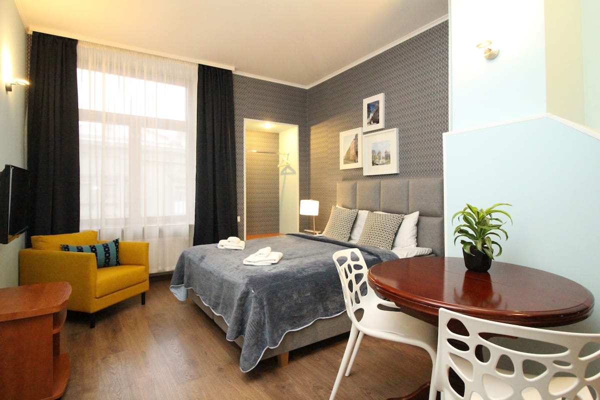 Ein Hotelzimmer mit einem Bett, einer Couch, einem Esstisch und einem Stuhl.