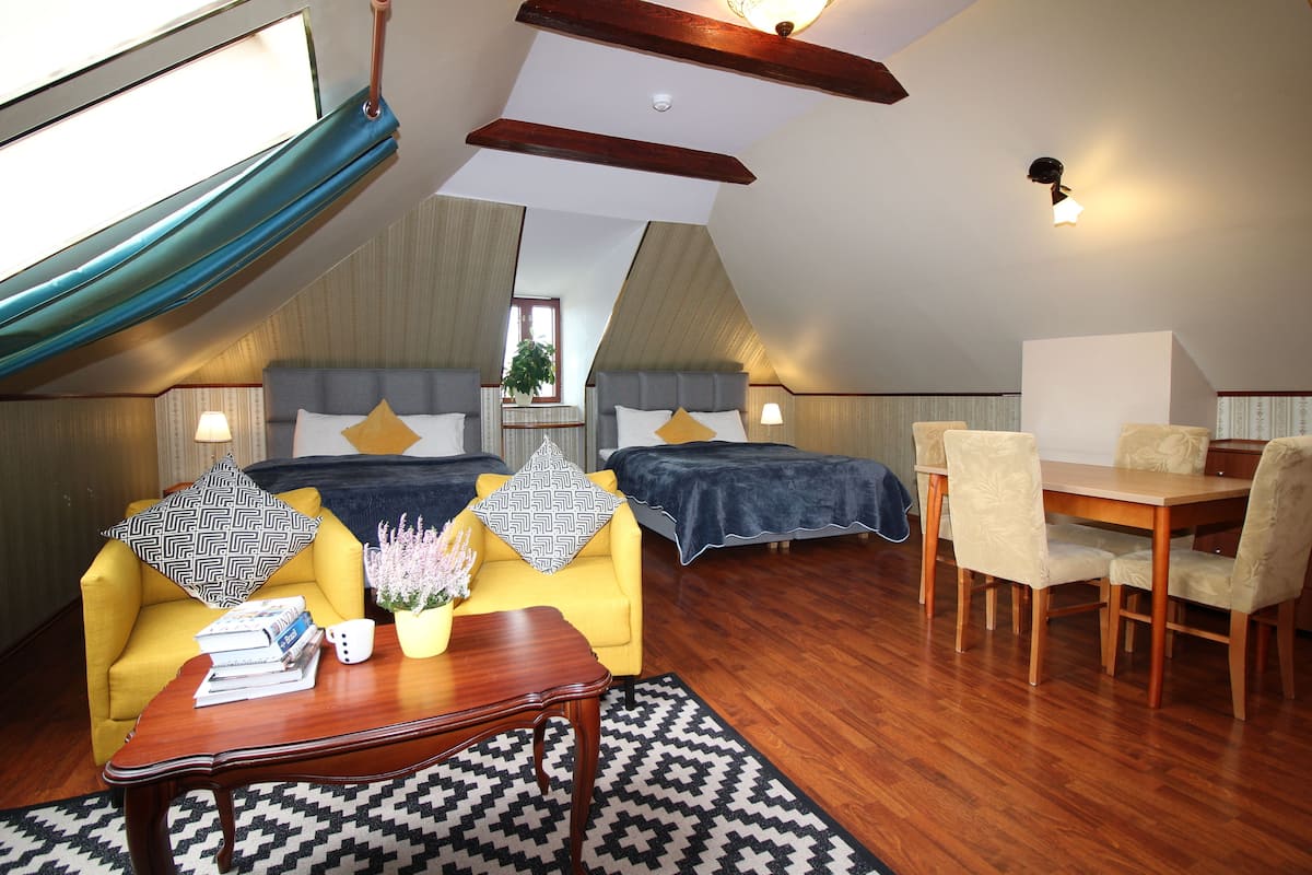 Ein gemütliches Zimmer mit einem Bett, einem Schlafsofa, einem Esstisch und einem Couchtisch.