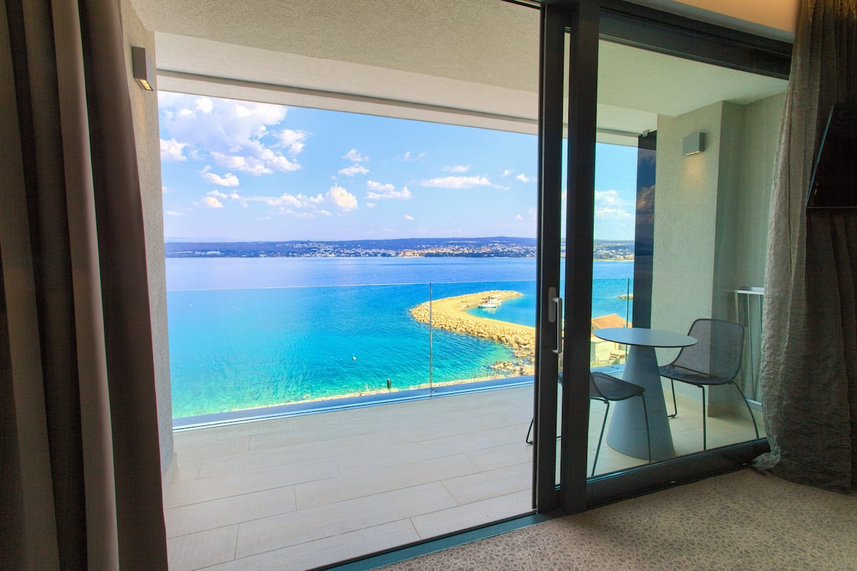 Ein Balkon mit freiem Blick auf das Meer und eine felsige Küste.