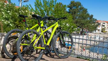 Una bicicleta amarilla estacionada cerca de una valla metálica junto al paseo marítimo.