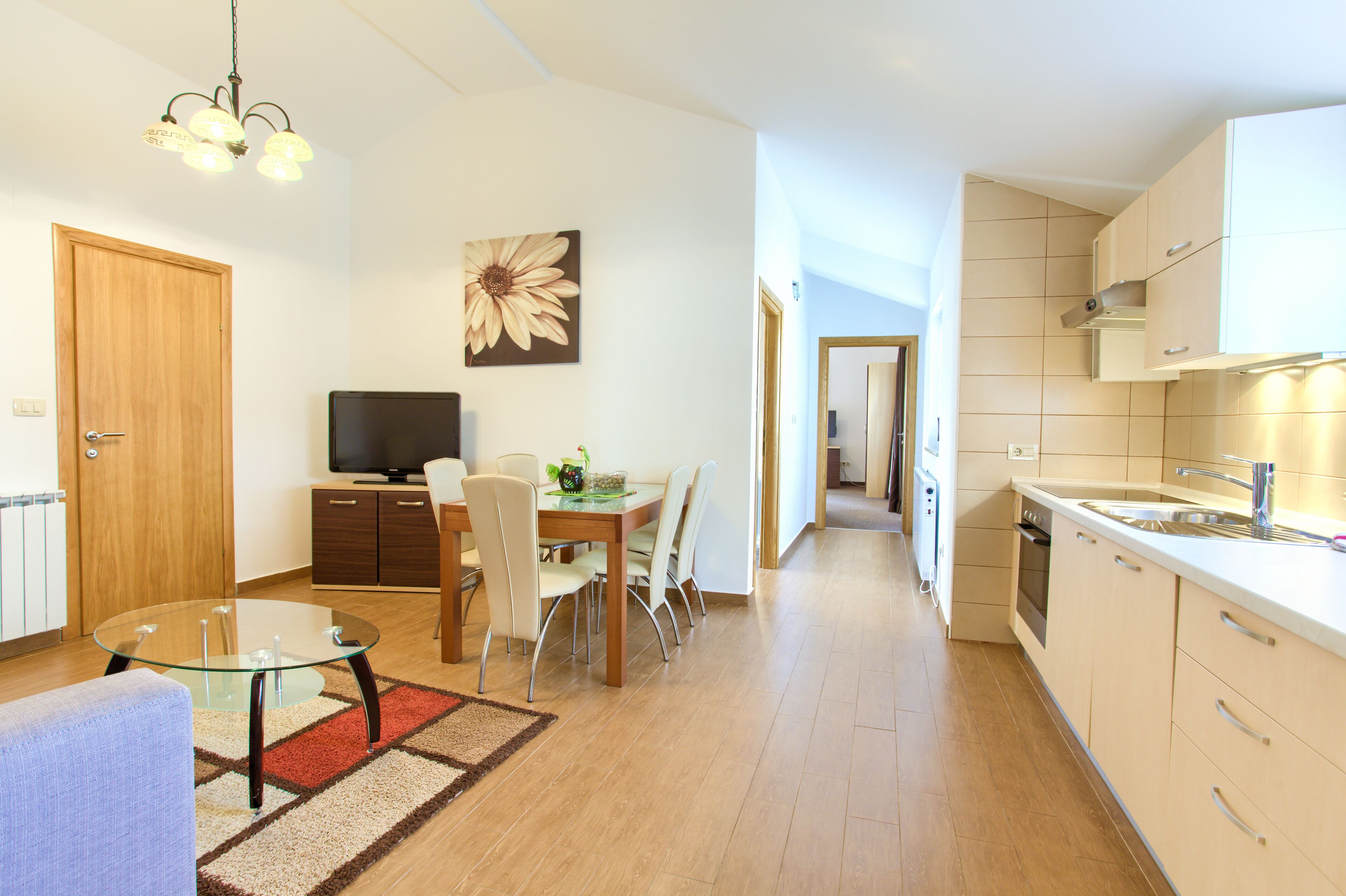 A modern apartment with a dining area, kitchen, and living space.