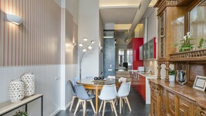 A modern dining area with a round table, six chairs, and a decorative cabinet. - Alcam Futbol (Barcelona)