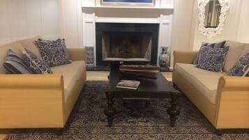 A living room with two beige sofas, a dark coffee table, and a patterned rug.