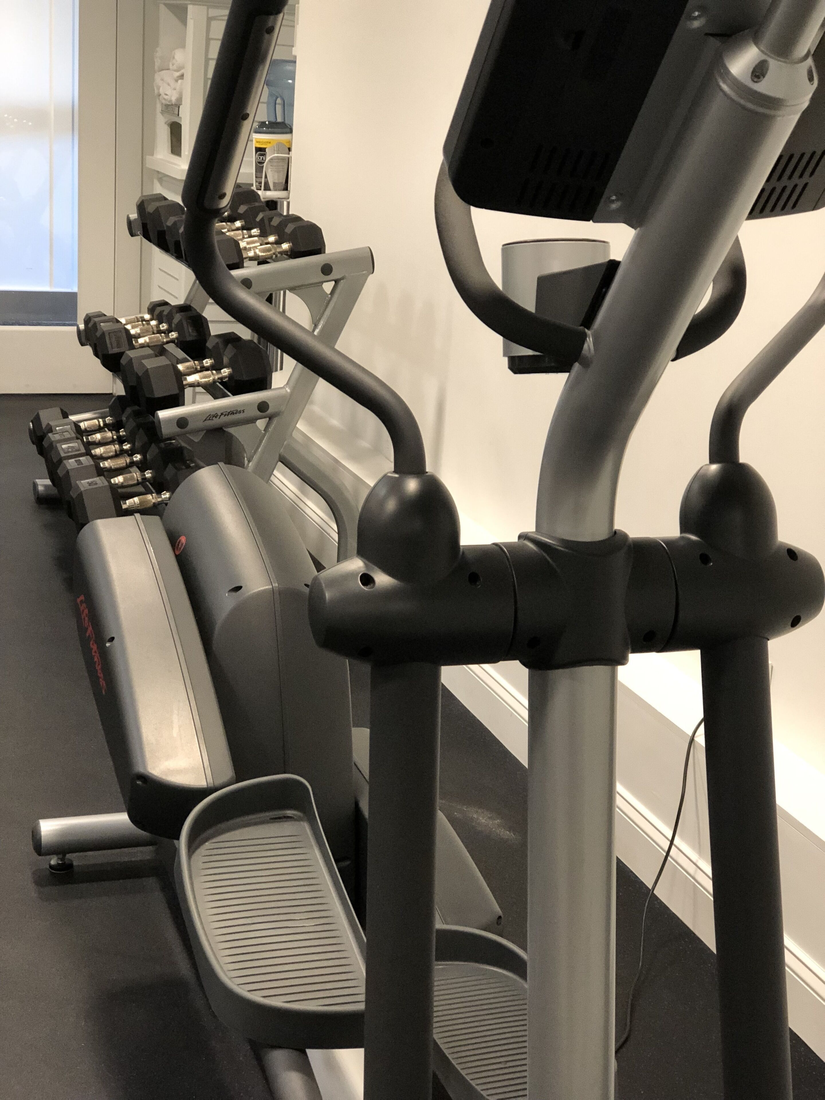 Une salle de sport équipée de matériel de cardio, notamment des tapis de course et des appareils elliptiques.