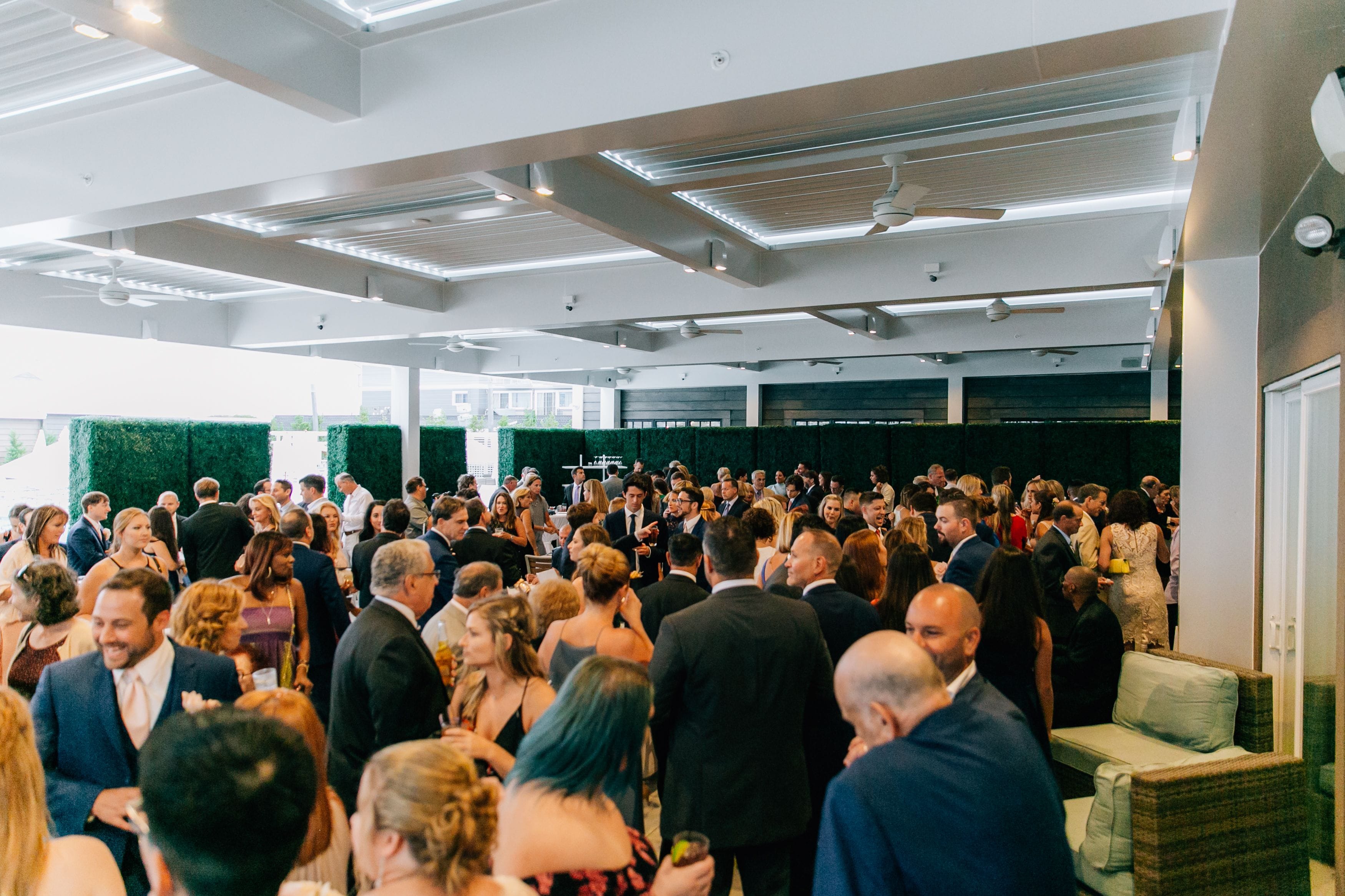 A crowded indoor event with a modern ceiling and seating area.