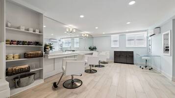 Experience a professional and welcoming space for hair styling services with three comfortable salon chairs and ample space for viewing.