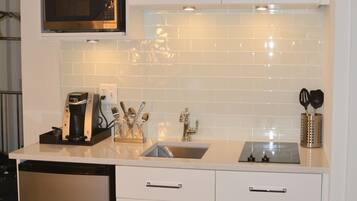 A modern kitchen with white cabinetry, a built-in microwave, and a dishwasher.