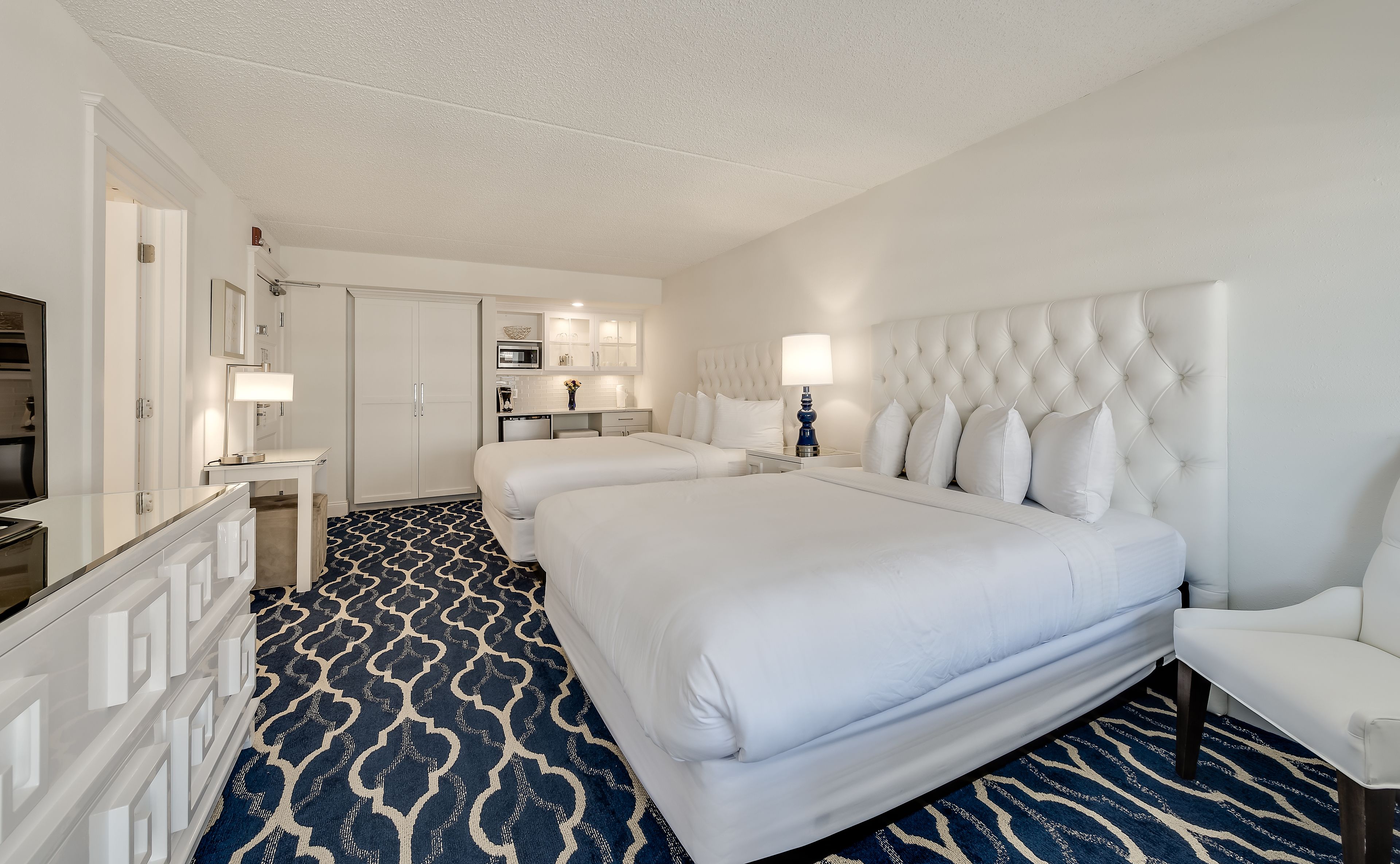 Ein Hotelzimmer mit einem großen Bett, einem Schreibtisch, einem Stuhl und einem Badezimmer.