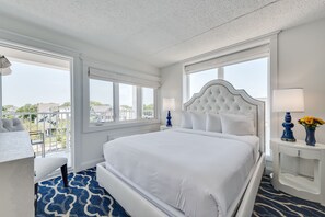 Un cuarto de hotel con una cama grande, un escritorio y vista a la ciudad.