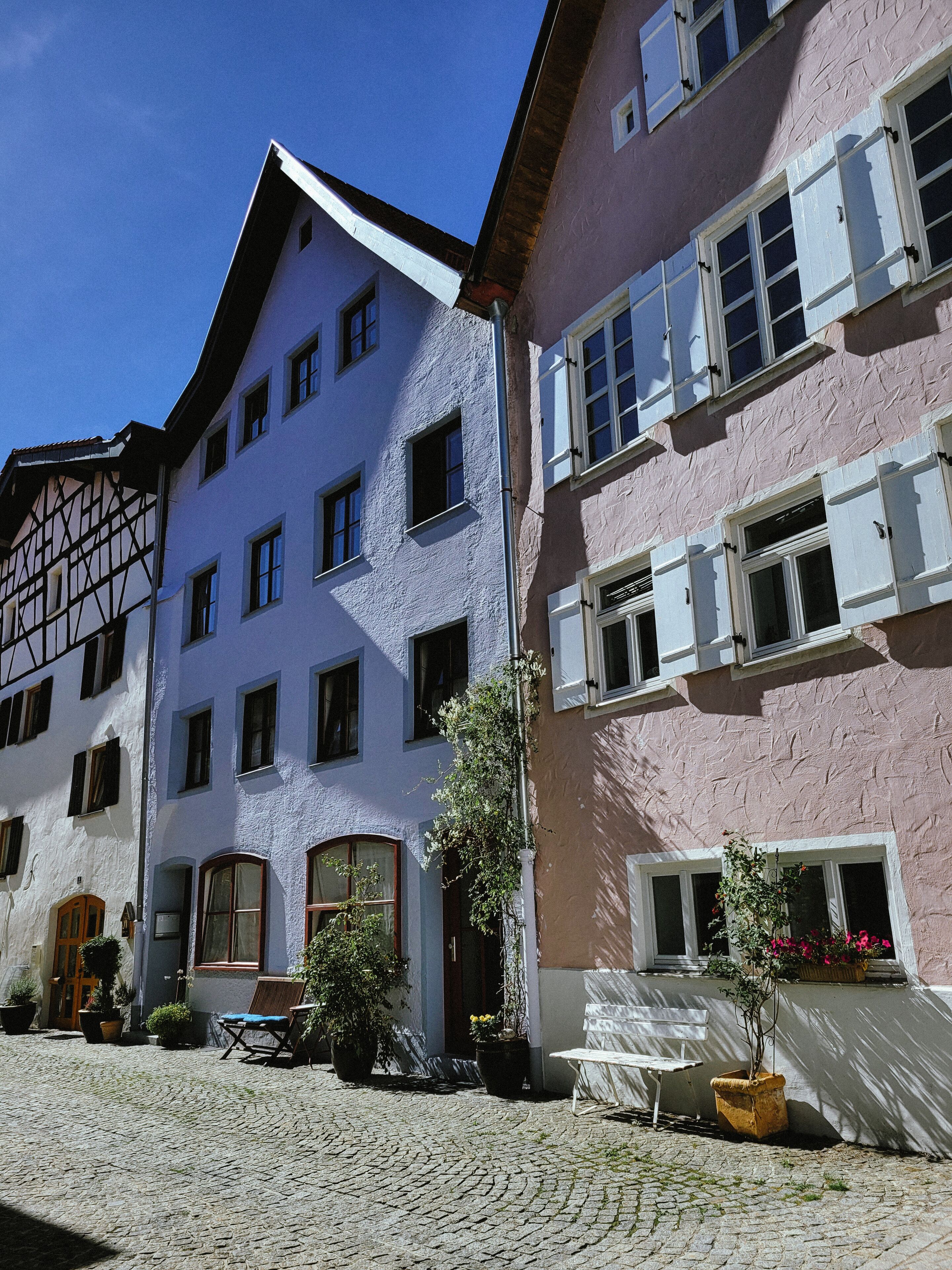 Ein traditionelles europäisches Gebäude mit zahlreichen Fenstern und einer gepflasterten Straße.