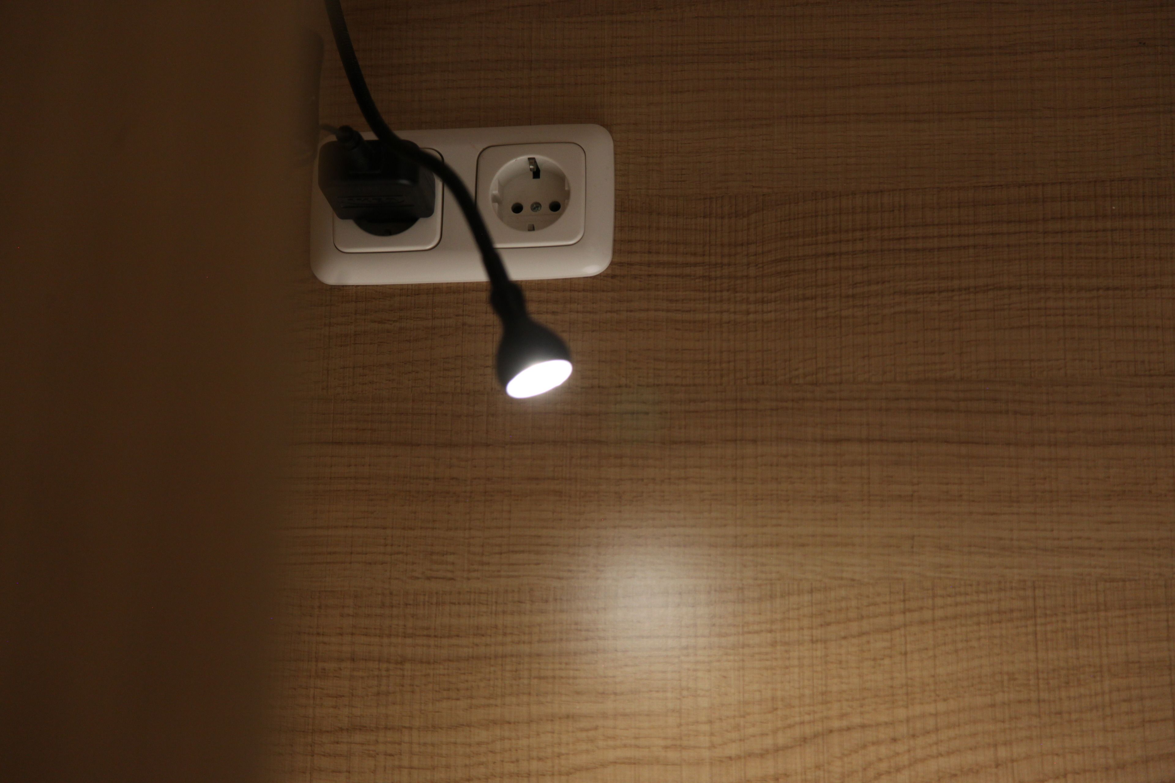 A power outlet on a wooden surface.