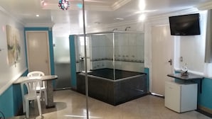 A bathroom with a glass-enclosed shower, a sink, and a toilet. - Motel dos Arcos (Porto Alegre)