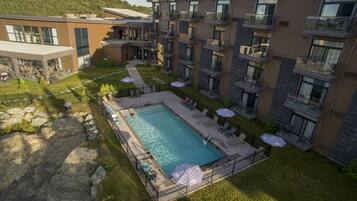 Un hôtel moderne doté d’une piscine, d’un espace extérieur aménagé et offrant une vue sur une région montagneuse.