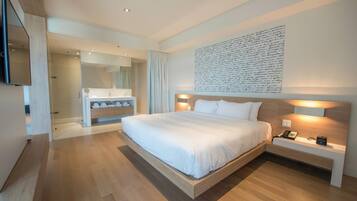 Un dormitorio moderno con una cama grande, mesitas de noche, un armario empotrado y una obra de arte colgada en la pared.