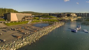 Un hôtel situé au bord de l’eau, avec une côte rocheuse, une piscine et un bâtiment doté d’un toit plat.
