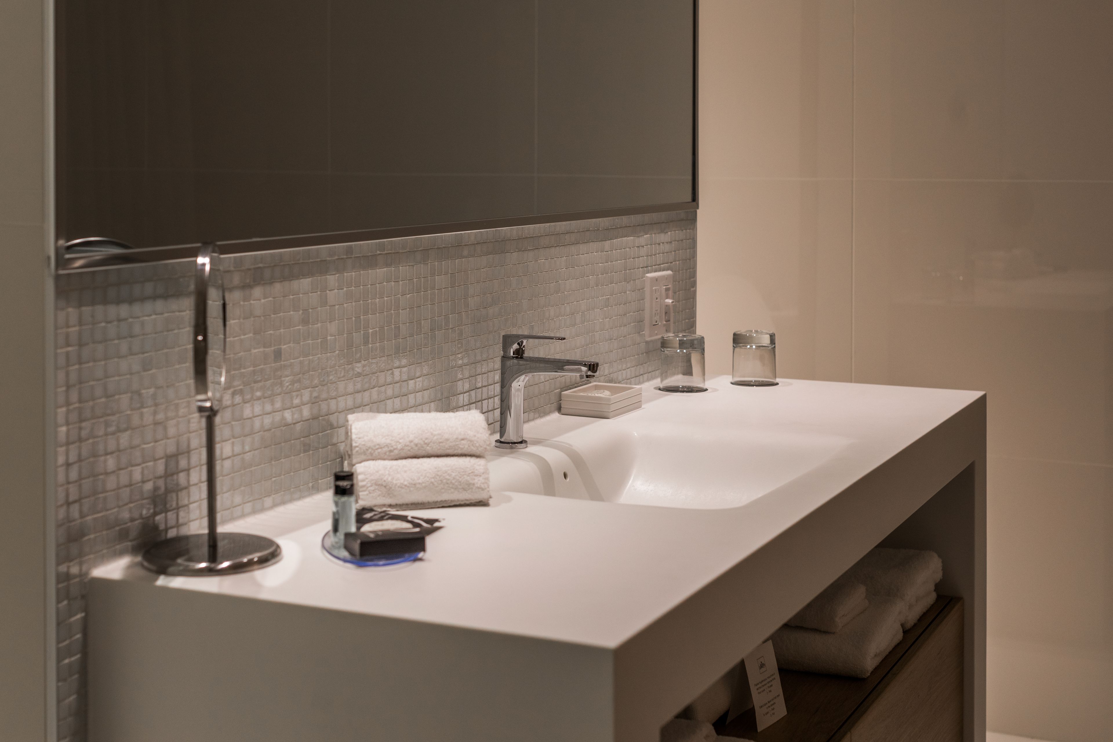 Une salle de bain moderne avec deux lavabos, un porte-serviettes et un miroir.