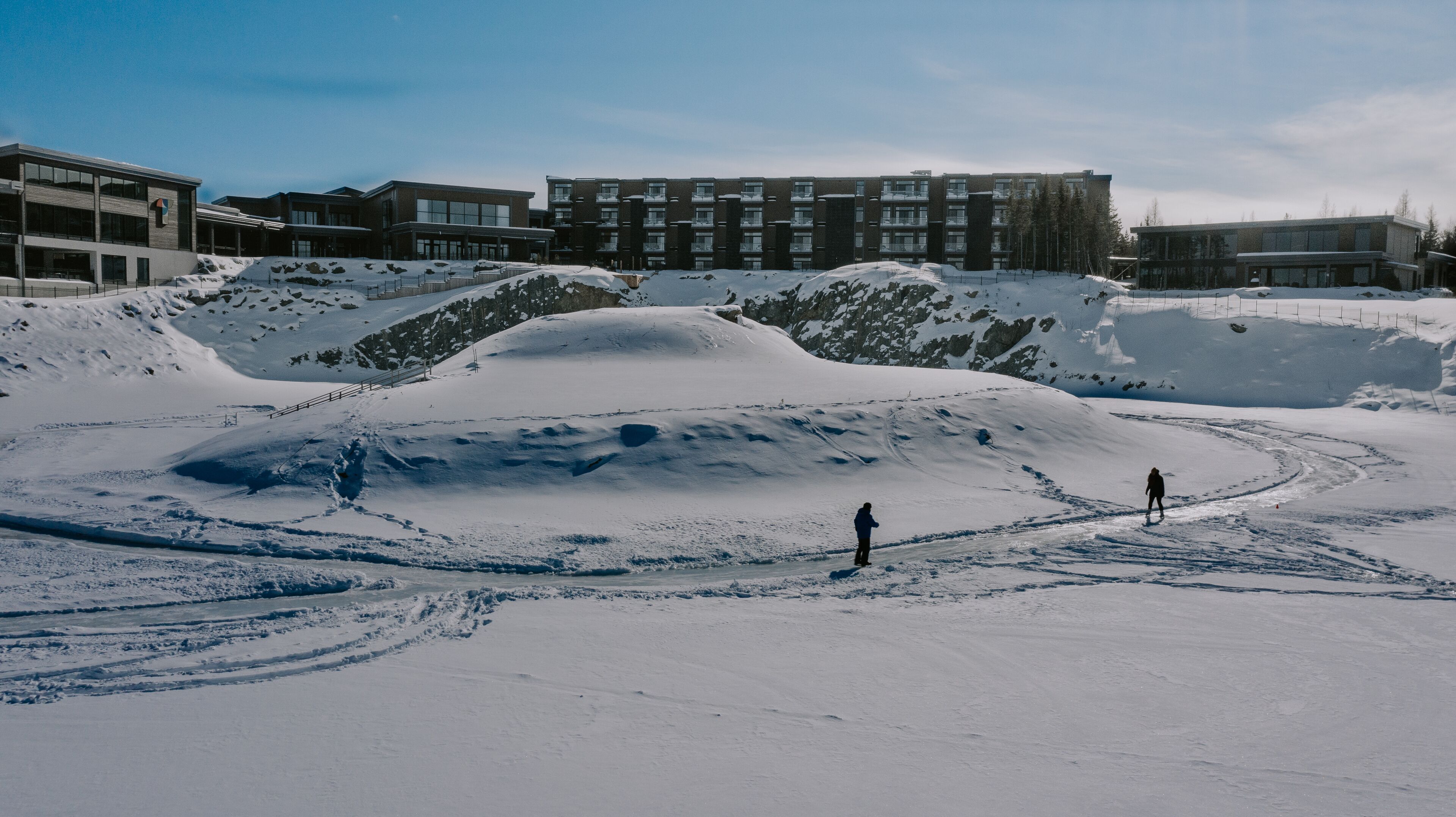 Un paisaje nevado con un edificio al fondo.