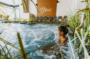 Una persona en un jacuzzi con una pared de madera y un cartel que dice