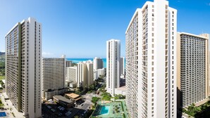 A high-rise hotel with multiple floors, a swimming pool, and a view of the ocean.