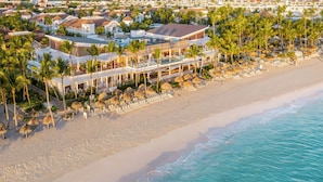 Un resort con varias edificaciones, una playa y palmeras.