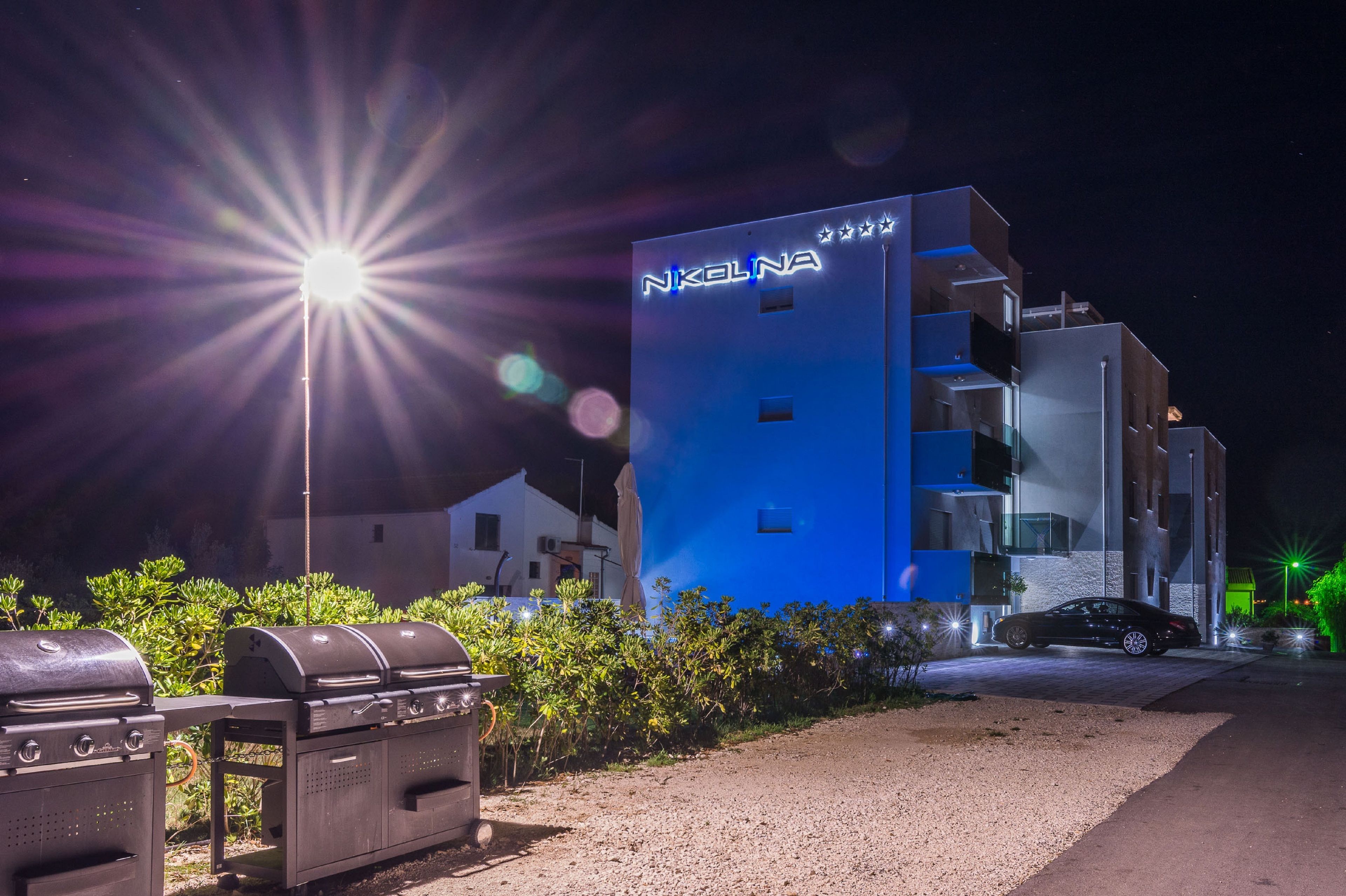 A modern building with a blue facade and a sign that reads "NKELNA".